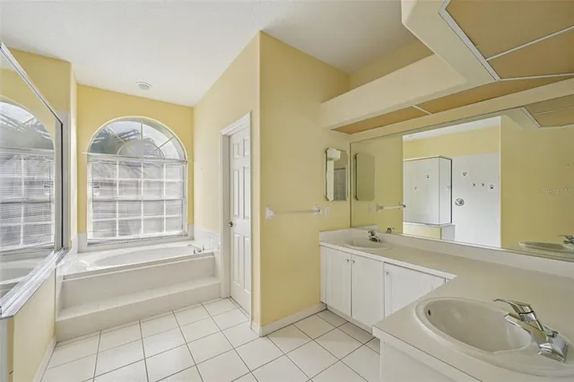a spacious bathroom with 2 sink mirror and a bathtub