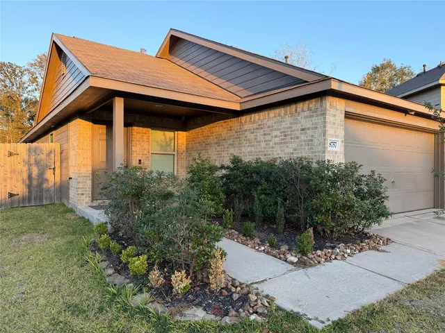 a backyard of a house with table and chairs under an umbrella