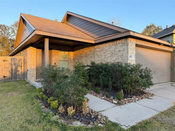 a backyard of a house with table and chairs under an umbrella