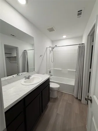 a bathroom with a granite countertop sink toilet a mirror and shower