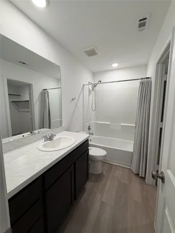a bathroom with a granite countertop sink toilet a mirror and shower