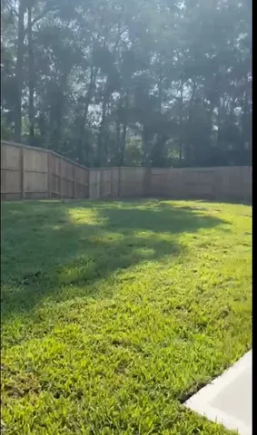 a view of yard with swimming pool and green space