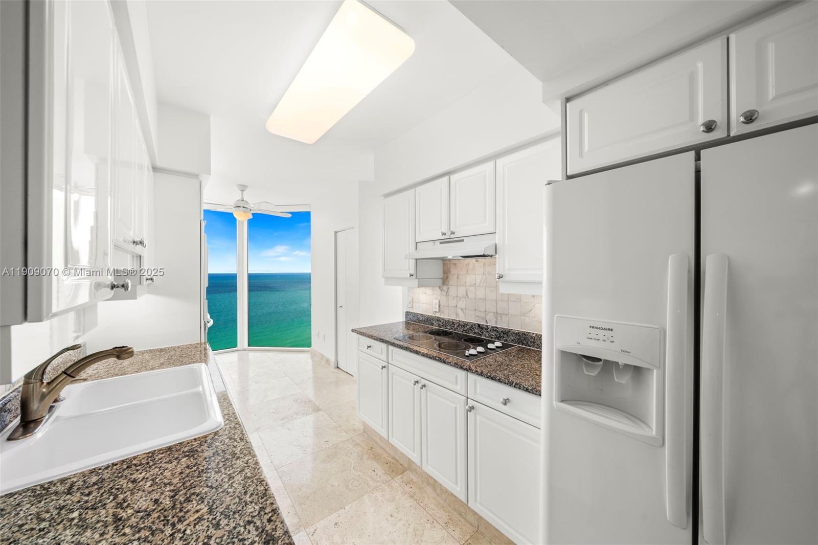 4775 Collins Avenue, Unit 1903 Miami Beach, FL 33140 - Photo 11 of 49 a kitchen with stainless steel appliances granite countertop a refrigerator and a stove top oven