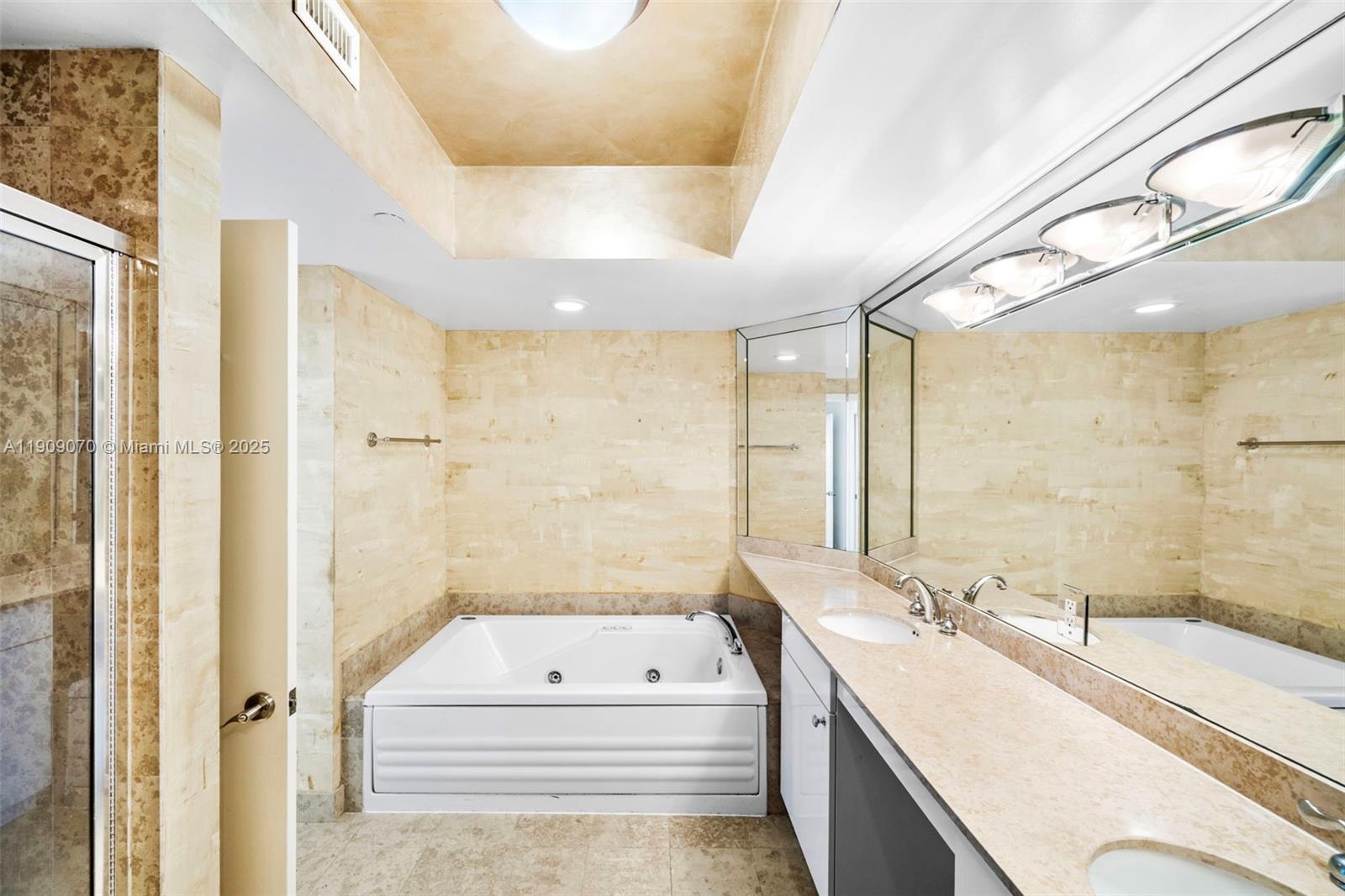 4775 Collins Avenue, Unit 1903 Miami Beach, FL 33140 - Photo 33 of 49 a bathroom with a tub sink and mirror