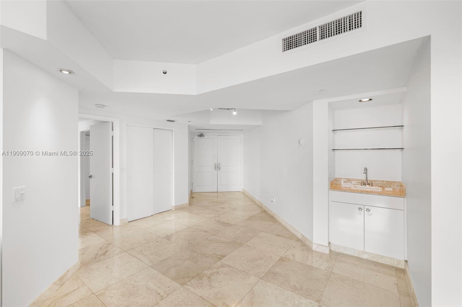 4775 Collins Avenue, Unit 1903 Miami Beach, FL 33140 - Photo 9 of 49 a view of a kitchen with white cabinets