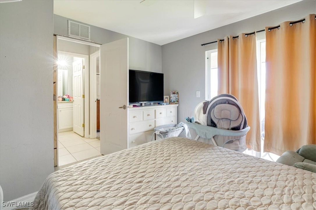 3980 Sunset Road Lehigh Acres, FL 33971 - Photo 16 of 42 a bedroom with a bed and a flat tv screen in it