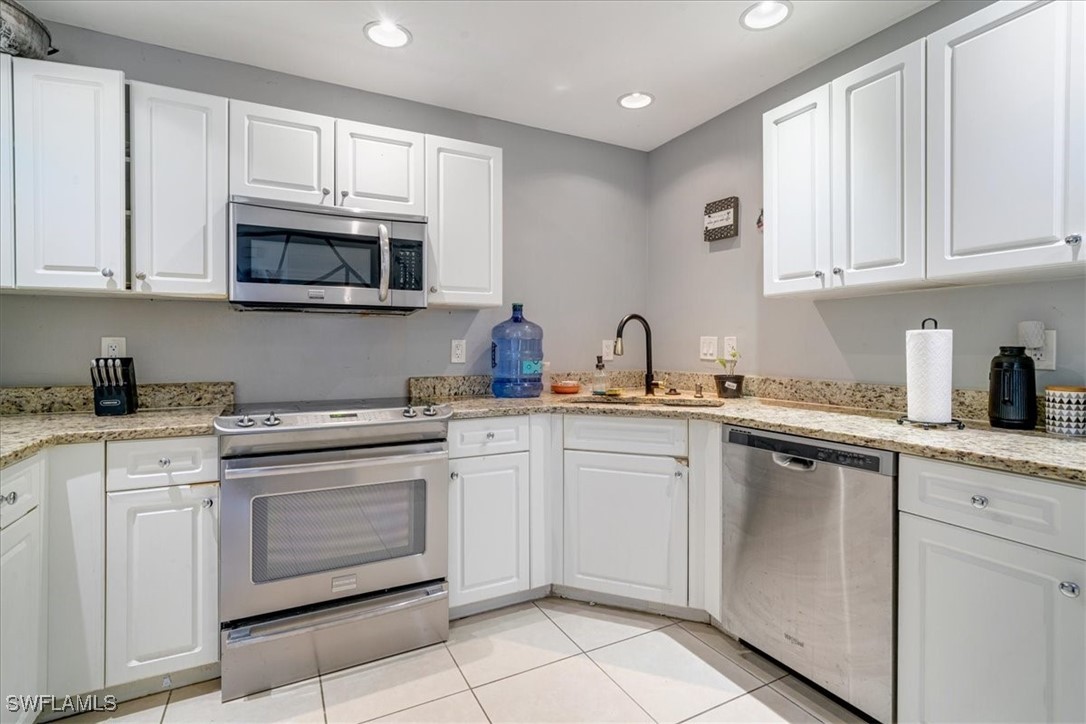 3980 Sunset Road Lehigh Acres, FL 33971 - Photo 21 of 42 a kitchen with cabinets stainless steel appliances and sink