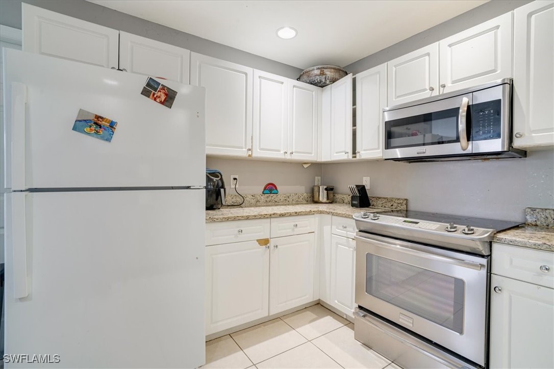 3980 Sunset Road Lehigh Acres, FL 33971 - Photo 22 of 42 a kitchen with stainless steel appliances granite countertop white refrigerator stove a microwave oven a sink and dishwasher