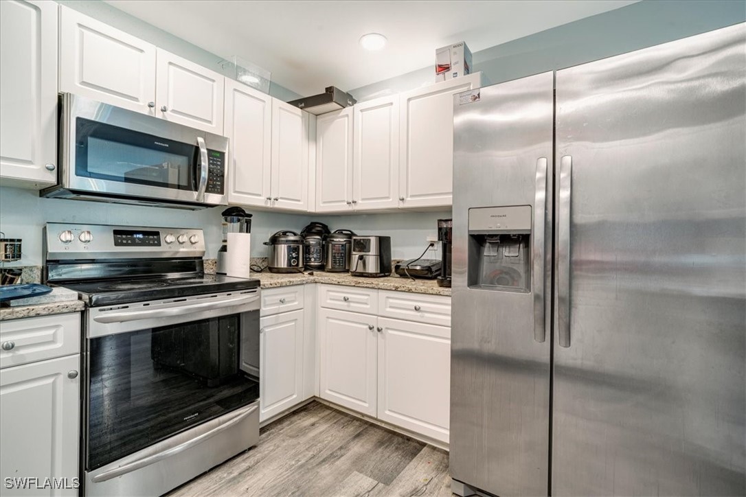 3980 Sunset Road Lehigh Acres, FL 33971 - Photo 27 of 42 a kitchen with cabinets stainless steel appliances and a counter space