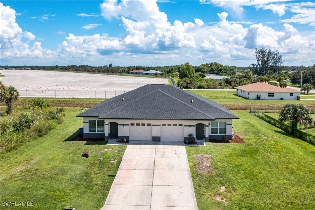3980 Sunset Road Lehigh Acres, FL 33971 - Photo 31 of 42 a aerial view of a house with swimming pool and a yard