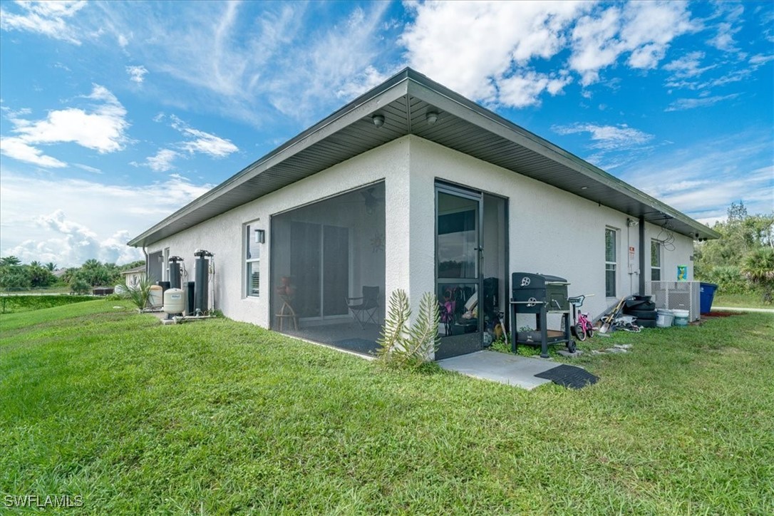 3980 Sunset Road Lehigh Acres, FL 33971 - Photo 35 of 42 a backyard of a house with table and chairs