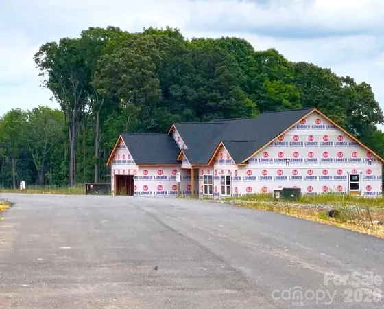 a view of a large house with a big yard and large trees