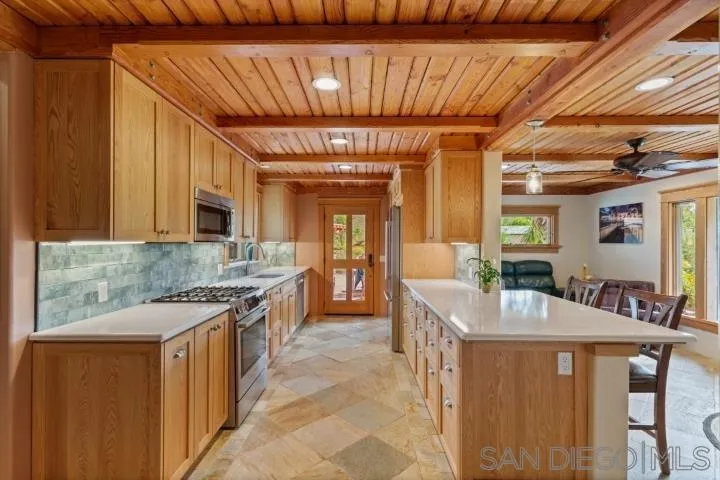 3097 Green Heather Lane Fallbrook, CA 92028 - Photo 11 of 37 a large kitchen with granite countertop a sink and cabinets