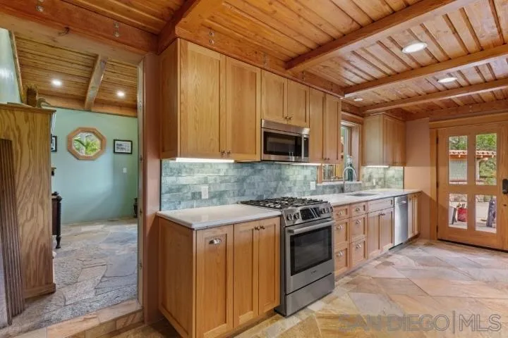 3097 Green Heather Lane Fallbrook, CA 92028 - Photo 13 of 37 a kitchen with a stove top oven sink and cabinets