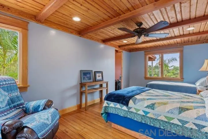 3097 Green Heather Lane Fallbrook, CA 92028 - Photo 21 of 37 a bedroom with a bed a couch and a window with the potted plants