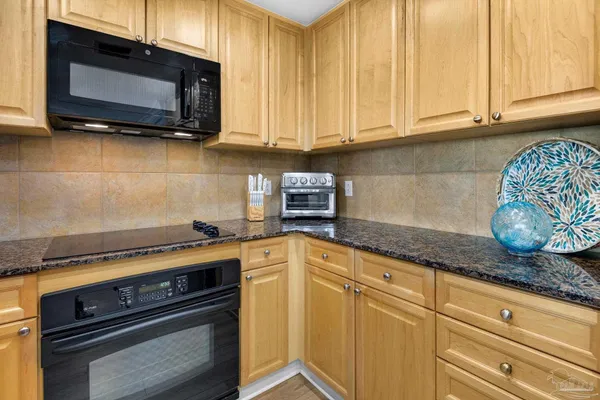 a kitchen with stainless steel appliances granite countertop a sink a stove and microwave