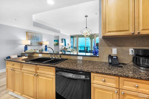 a kitchen with granite countertop a sink a stove and cabinets