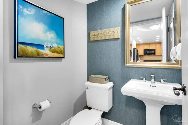 a bathroom with a toilet a sink and mirror