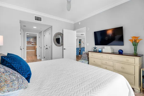 a bedroom with a bed and a flat tv screen on wall