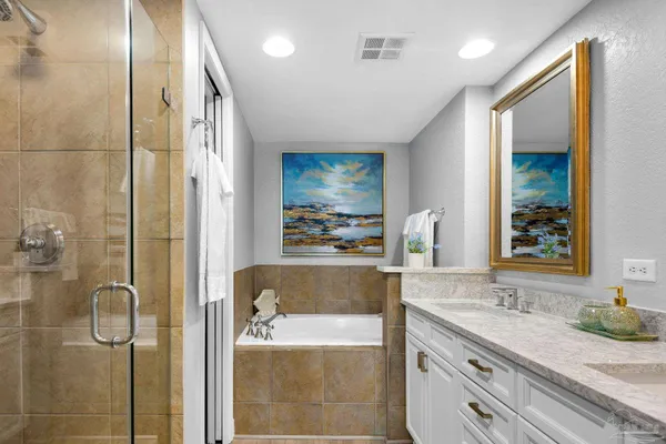 a bathroom with a granite countertop sink a mirror and shower