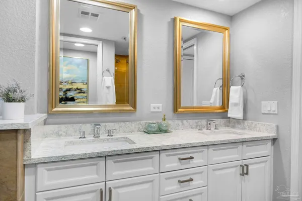 a bathroom with double sink and a mirror