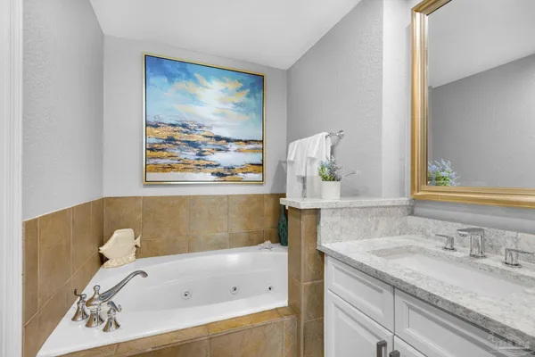 a bathroom with a tub sink and mirror
