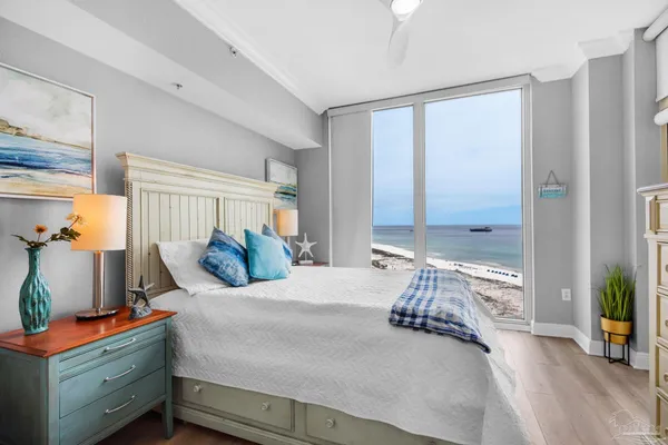 a bedroom with a bed and large windows