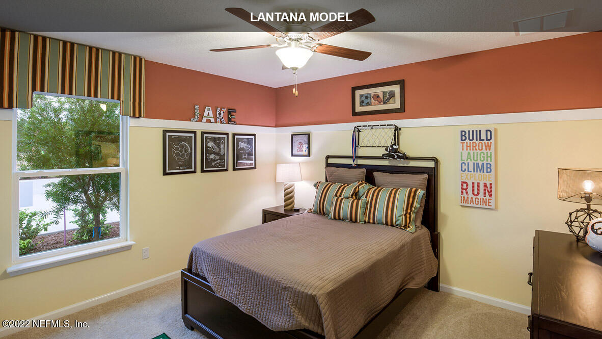 65696 Edgewater Drive Yulee, FL 32097 - Photo 11 of 44 a bedroom with a bed and a chandelier