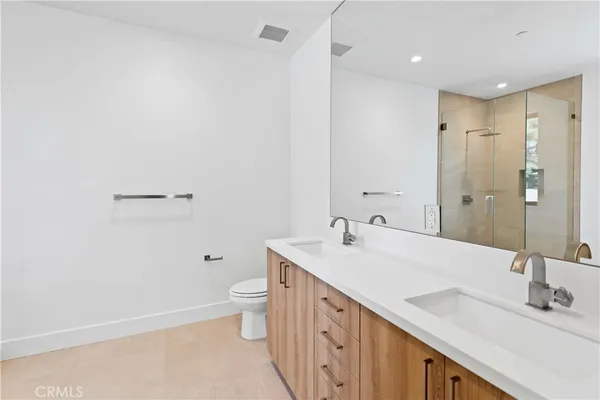 a spacious bathroom with a double vanity sink toilet and a mirror