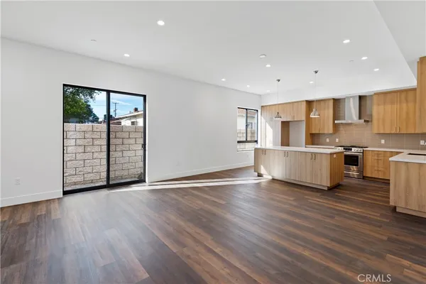 a view of a kitchen with wooden floor and electronic appliances