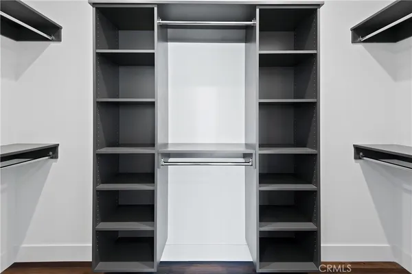 a view of walk in closet with empty racks