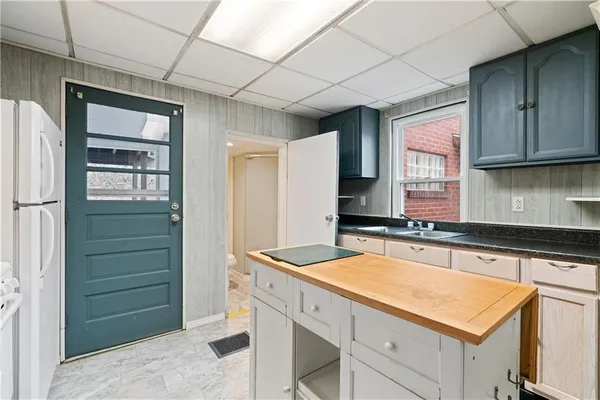 a kitchen with granite countertop white cabinets and white appliances