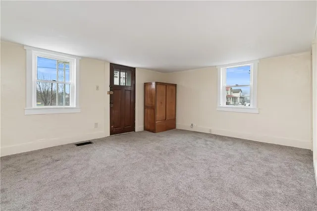 an empty room with windows and closet