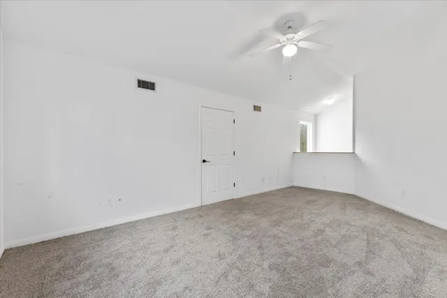 an empty room with fan and windows