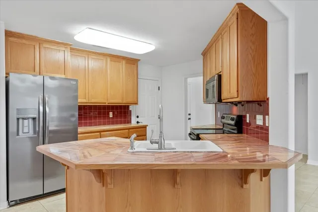 a kitchen with stainless steel appliances granite countertop a sink and a refrigerator
