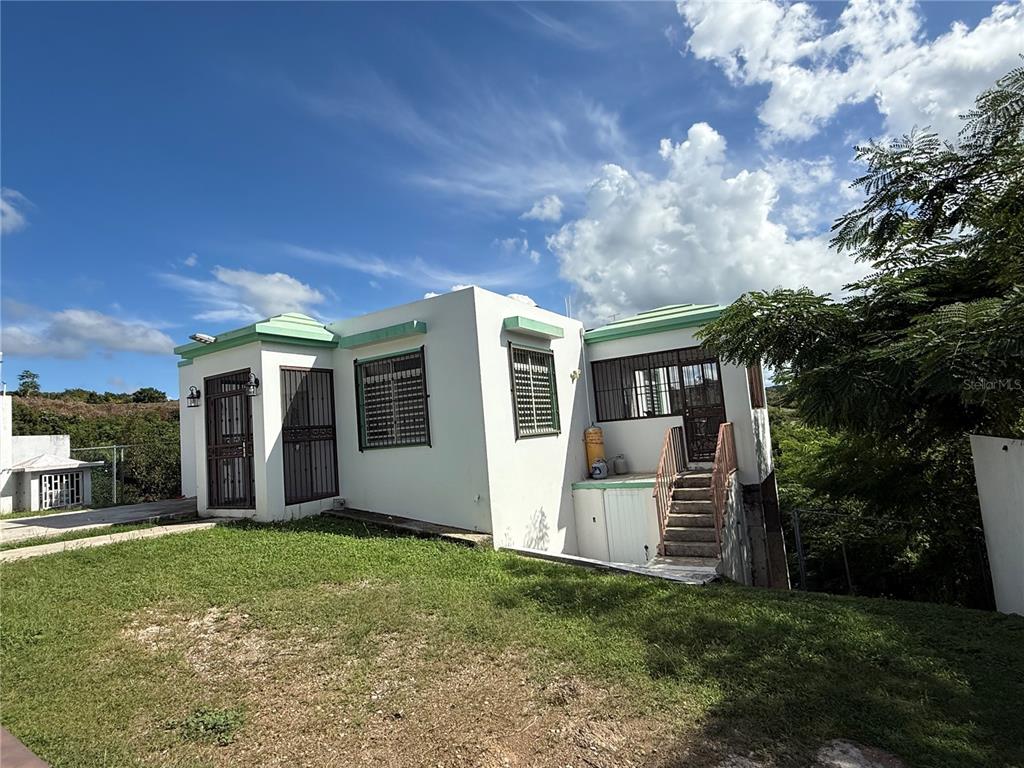 411 Bo Calvache Rincon, PR 00677 - Photo 1 of 14 a view of a house with big yard and large tree