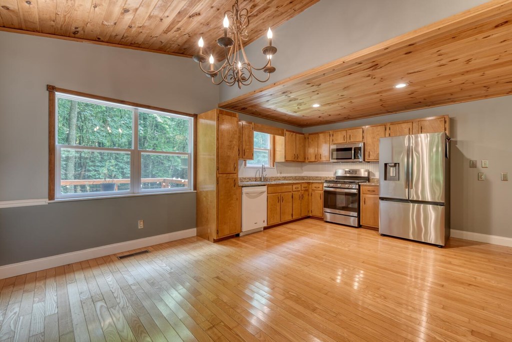 550 Watson Road Epworth, GA 30541 - Photo 25 of 63 a kitchen with stainless steel appliances granite countertop a refrigerator a stove a sink dishwasher a oven with white cabinets and wooden floor