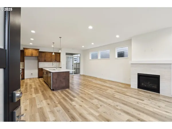 a view of kitchen with kitchen island granite countertop a stove top oven a sink and a refrigerator
