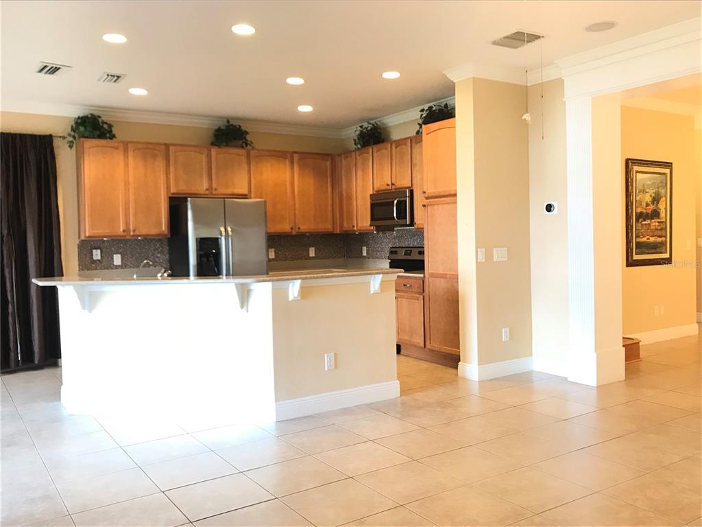 10505 Willow Ridge Loop Orlando, FL 32825 - Photo 12 of 45 a kitchen with stainless steel appliances a refrigerator and a stove top oven