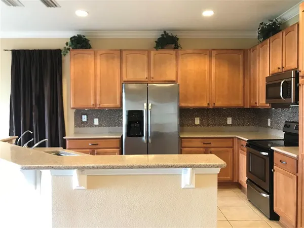 a kitchen with stainless steel appliances granite countertop a sink a stove and refrigerator