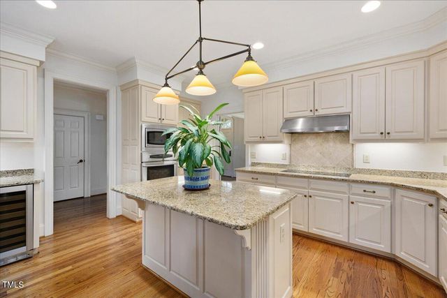 a kitchen with stainless steel appliances granite countertop a sink a stove and wooden floors
