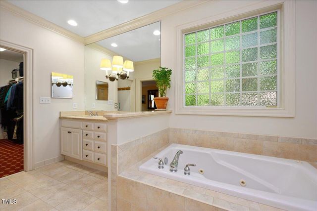 a bathroom with a bathtub sink and mirror
