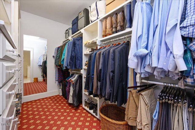 a view of walk in closet with clothes and shoes