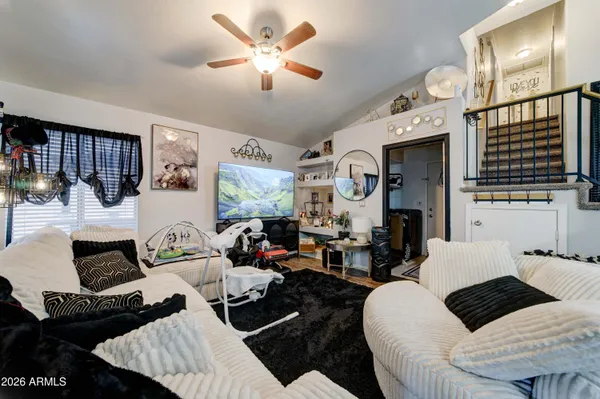 a living room with furniture kitchen view and a chandelier