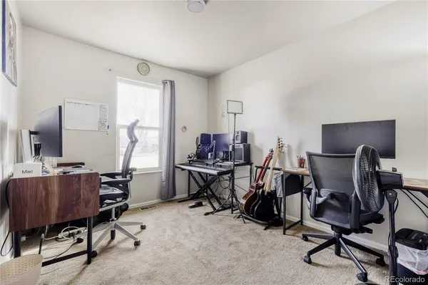 a view of a workspace with furniture and a window
