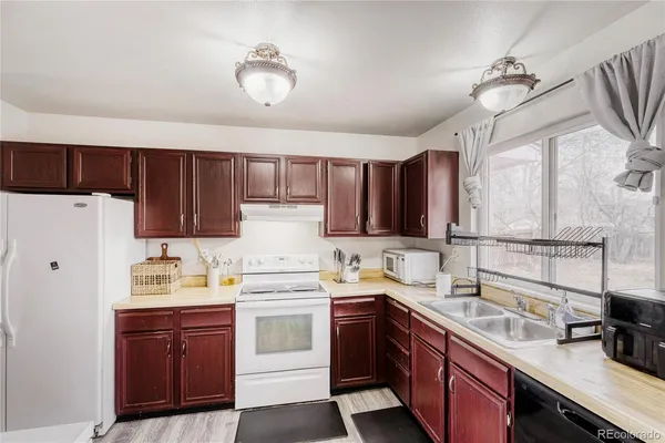 a kitchen with a sink dishwasher a stove a refrigerator and cabinets