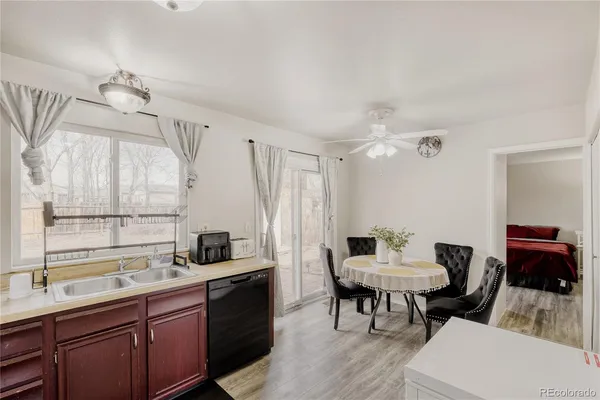 a kitchen with a dining table chairs and white cabinets