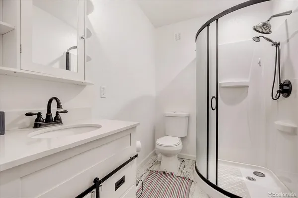 a bathroom with a sink a toilet and shower