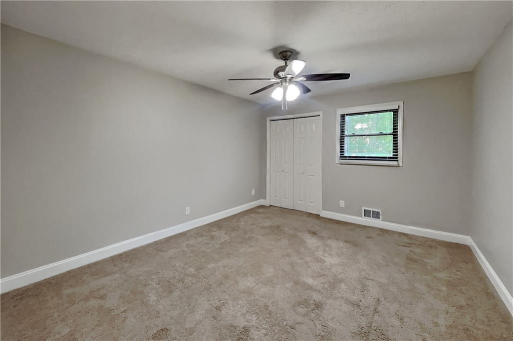464 Ridgemont Drive Lawrenceville, GA 30046 - Photo 11 of 22 an empty room with windows and fan