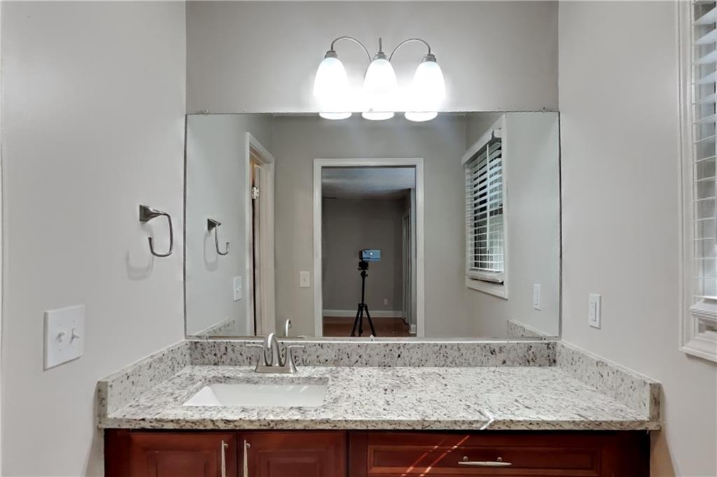 464 Ridgemont Drive Lawrenceville, GA 30046 - Photo 10 of 22 a bathroom with a granite countertop sink and a mirror